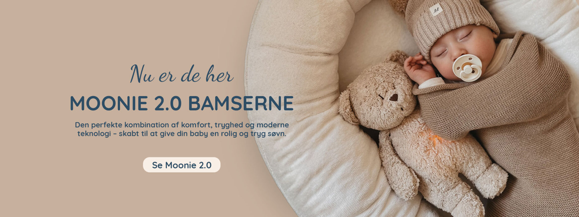 Baby der ligger og sover med en sød Moonie bamse med lys i maven