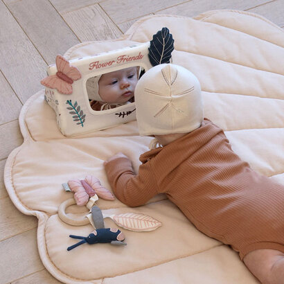 Baby der ligger på en tæppe og kigger i et spejl