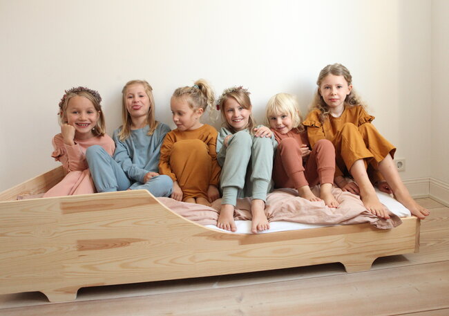 Gravid kvinde der sidder med en ammepude som støtte mens hun læser en bog